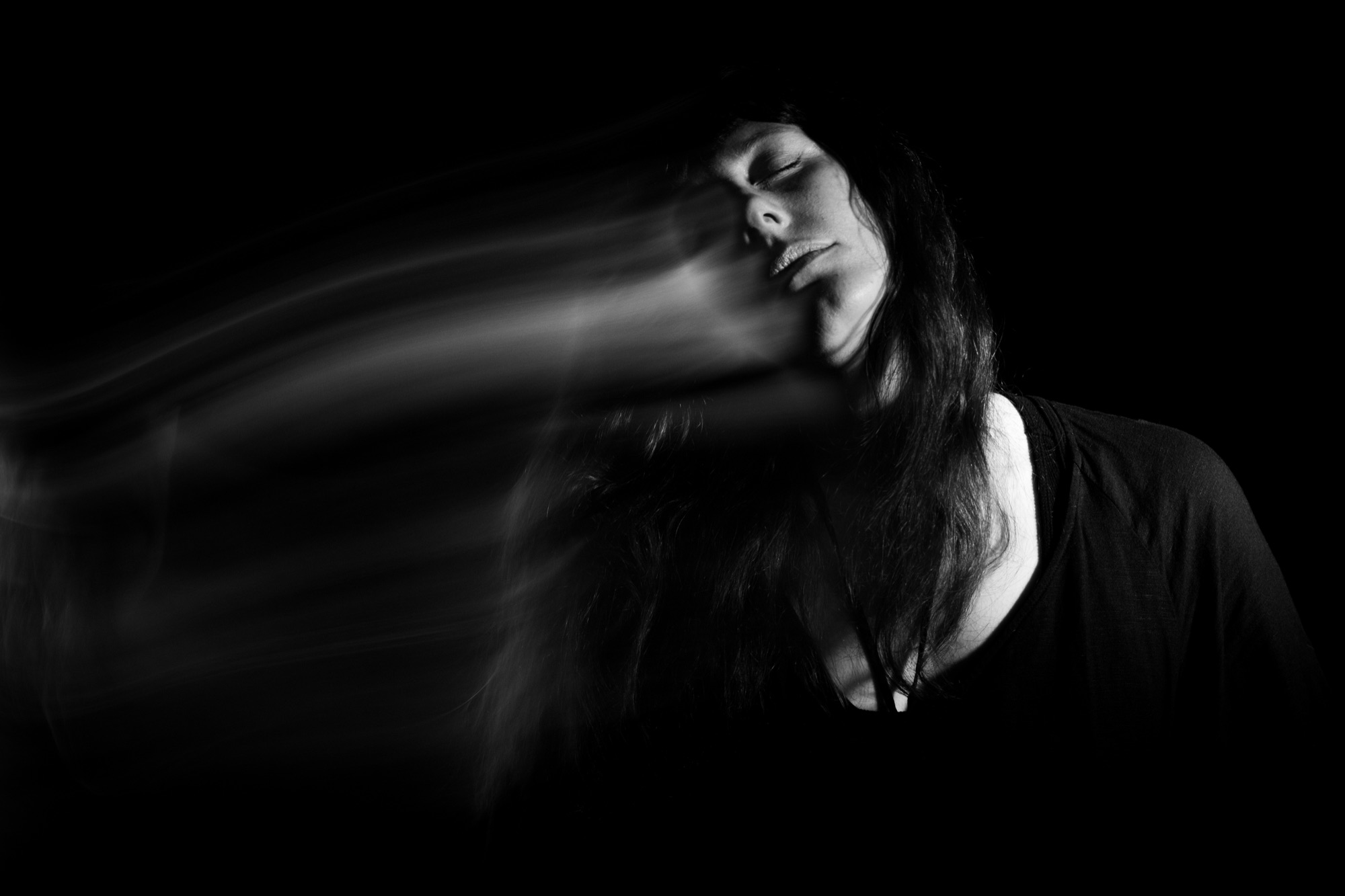 Jolanda Moletta in black and white, eyes closed, her hair blurred in motion